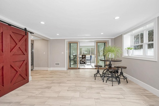 dining area with a barn door and crown molding