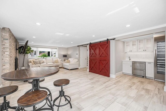 living room featuring a barn door and crown molding