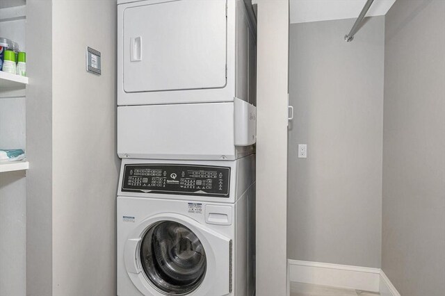 clothes washing area with stacked washer and dryer