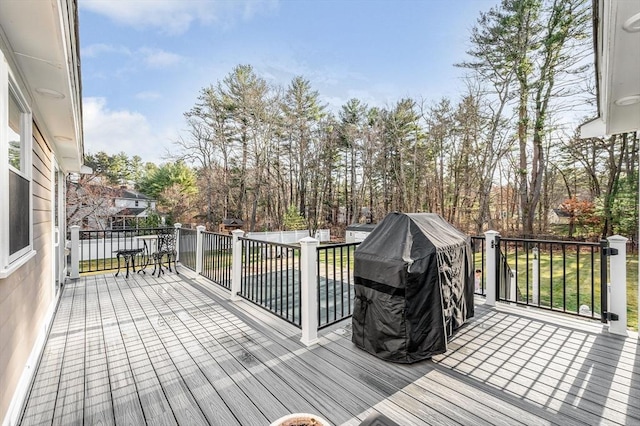 wooden terrace featuring a grill and a yard