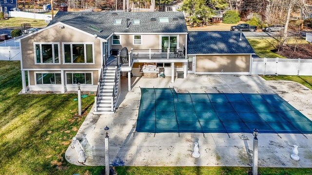 rear view of house featuring a patio area, a yard, and a covered pool