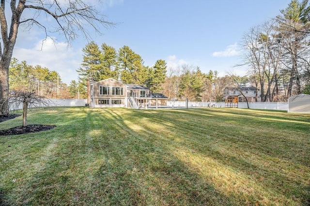 view of yard featuring a sunroom and a water view