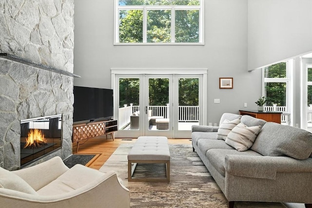 19 Hawthorn Rd, Amherst, MA 01002 - living area featuring a towering ceiling, a fireplace, wood finished floors, and french doors