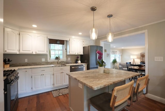 99 Edgehill Rd, Norwood, MA 02062 - kitchen with appliances with stainless steel finishes, dark wood finished floors, a kitchen bar, white cabinetry, and ornamental molding