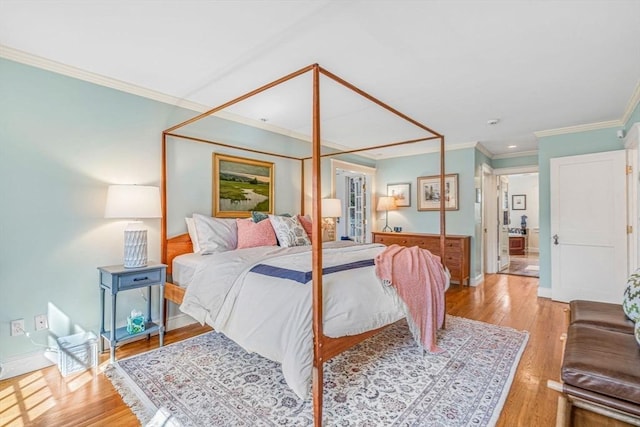 bedroom featuring ornamental molding, light wood-style flooring, and baseboards