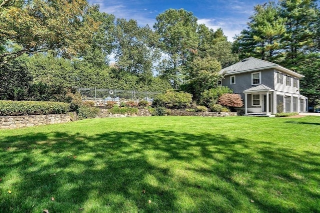 view of yard with an attached garage and fence