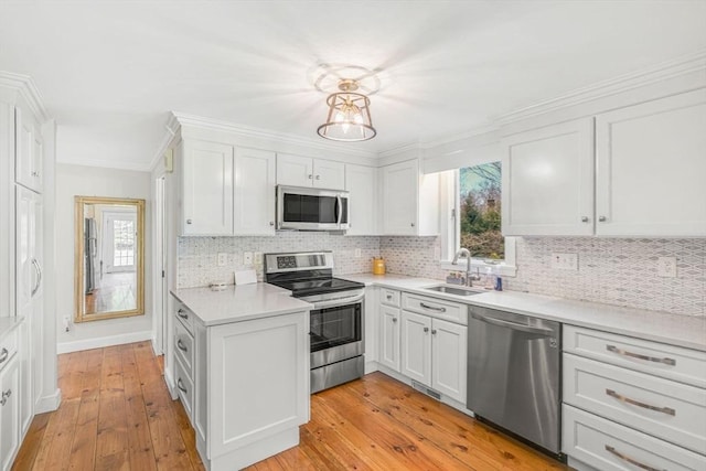 kitchen with stainless steel appliances, plenty of natural light, a sink, and white cabinets