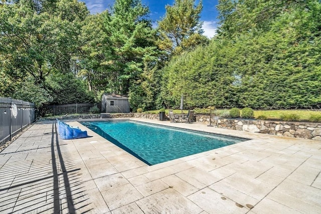 view of pool with a storage shed, a fenced in pool, an outbuilding, fence, and a patio area