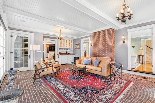 living room featuring brick floor, stairs, beamed ceiling, an inviting chandelier, and crown molding