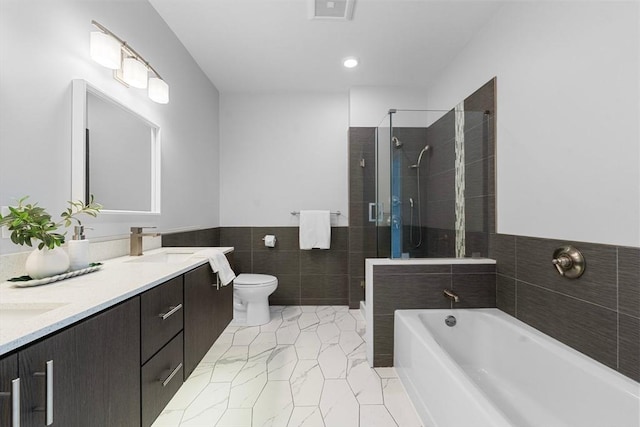 bathroom featuring a shower stall, a sink, visible vents, tile walls, and a garden tub