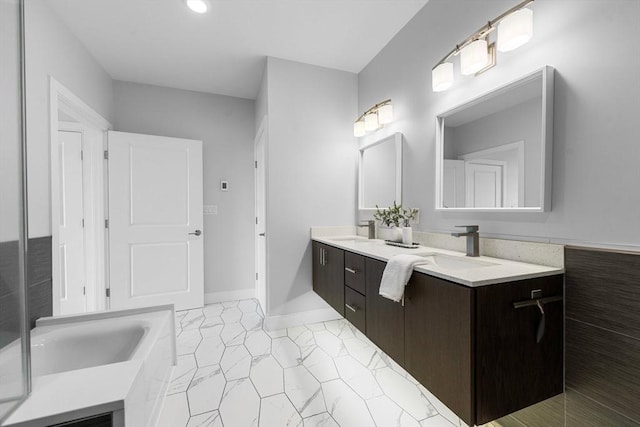 full bathroom with recessed lighting, a bathtub, double vanity, and a sink