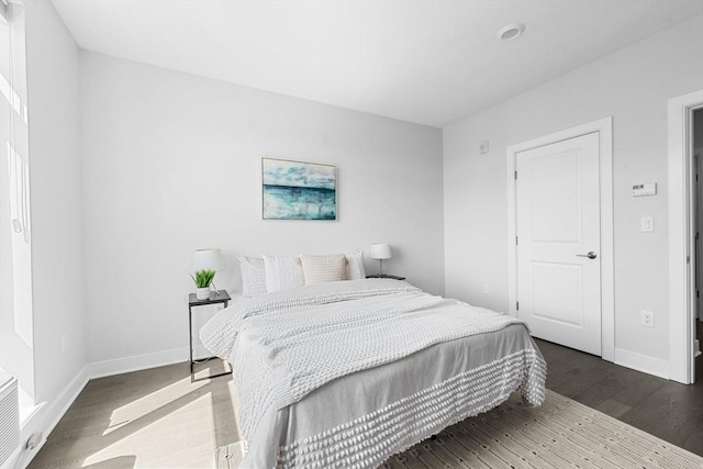 bedroom with dark wood-style floors and baseboards