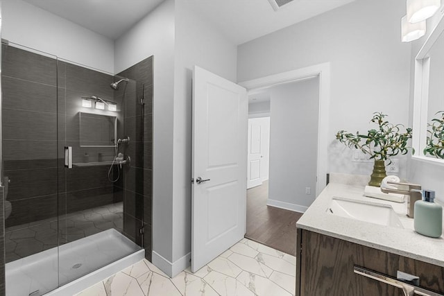 full bathroom featuring baseboards, a stall shower, marble finish floor, and vanity