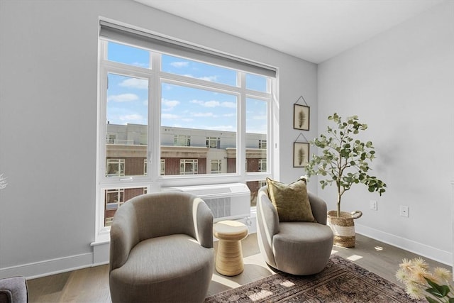 sitting room with baseboards and wood finished floors