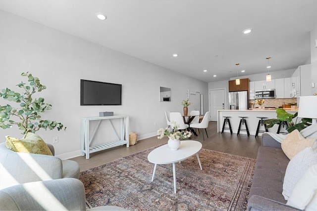living area with dark wood-style floors, recessed lighting, and baseboards