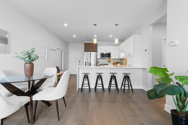 dining area with recessed lighting, dark wood finished floors, and baseboards