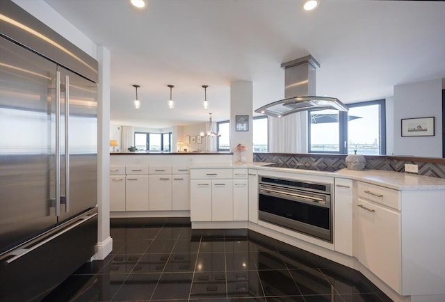 2001 Marina Dr Unit 707, Quincy, MA 02171 - kitchen with appliances with stainless steel finishes, island range hood, a peninsula, white cabinets, and light countertops
