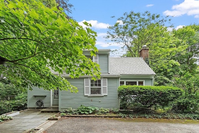 14 Upland Rd, Andover, MA 01810 - view of side of home with a chimney and roof with shingles