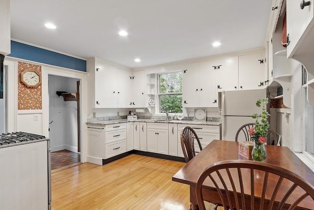 14 Upland Rd, Andover, MA 01810 - kitchen with stainless steel gas stove, white cabinetry, freestanding refrigerator, light wood-type flooring, and open shelves