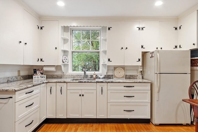 14 Upland Rd, Andover, MA 01810 - kitchen with freestanding refrigerator, open shelves, white cabinetry, light wood finished floors, and light stone counters