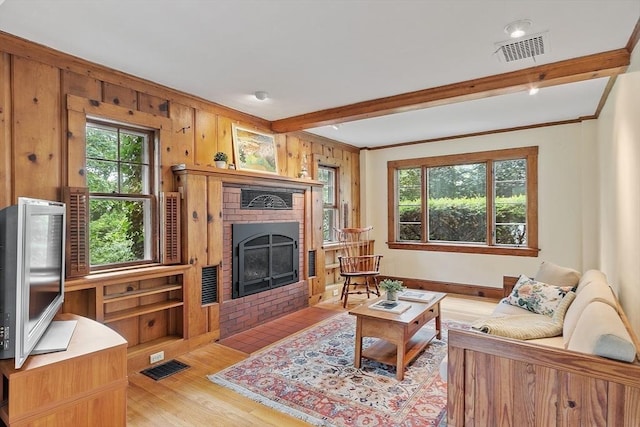 14 Upland Rd, Andover, MA 01810 - living area with plenty of natural light, light wood-style floors, beamed ceiling, a brick fireplace, and wood walls