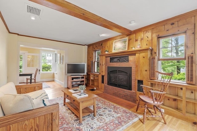 14 Upland Rd, Andover, MA 01810 - living area featuring light wood-type flooring, ornamental molding, plenty of natural light, a fireplace, and beam ceiling