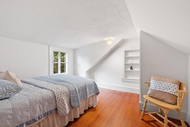 14 Upland Rd, Andover, MA 01810 - bedroom with vaulted ceiling, wood-type flooring, and a textured ceiling