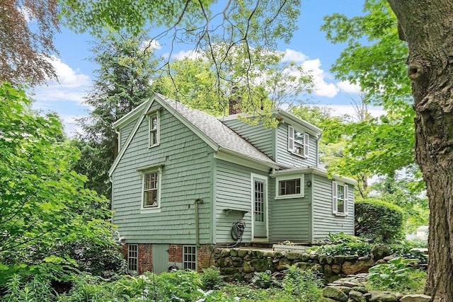 14 Upland Rd, Andover, MA 01810 - view of side of property featuring roof with shingles and a chimney