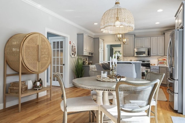 dining room featuring crown molding, an inviting chandelier, and light hardwood / wood-style floors