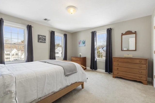 bedroom featuring multiple windows and light carpet