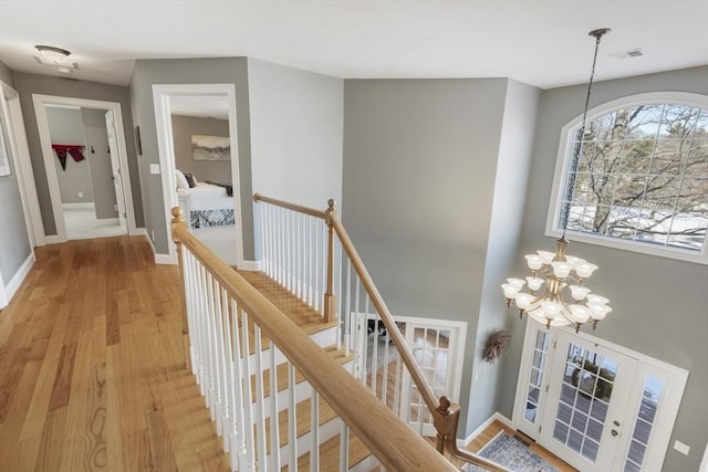 hall featuring an inviting chandelier and light hardwood / wood-style flooring