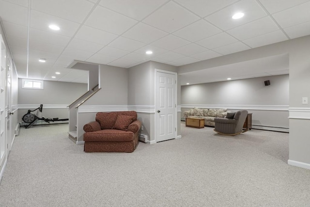 sitting room with a baseboard radiator, a paneled ceiling, and light carpet