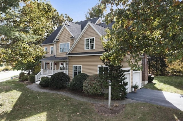 exterior space featuring a garage, a lawn, and a porch