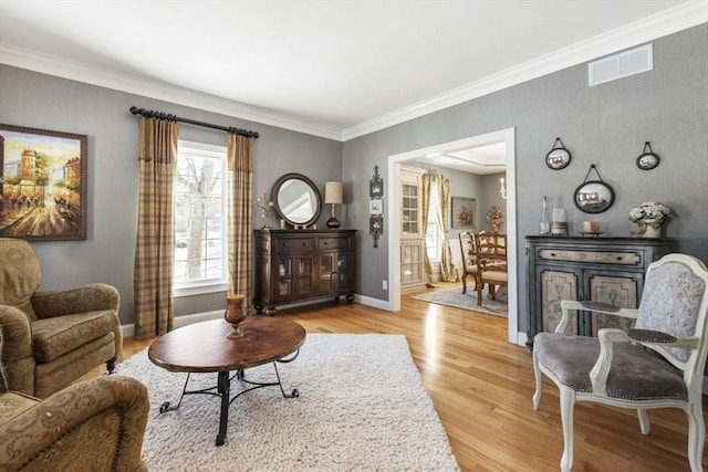 living area featuring crown molding and light wood-type flooring