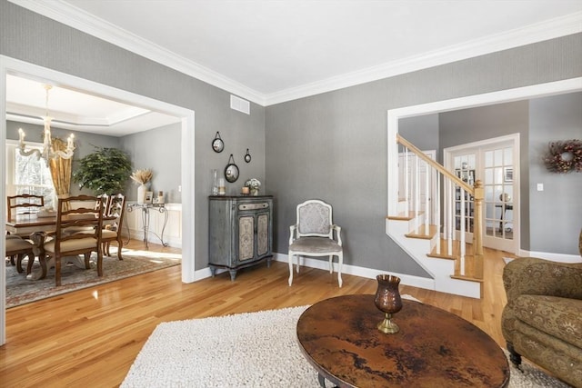 sitting room with an inviting chandelier, ornamental molding, and hardwood / wood-style floors