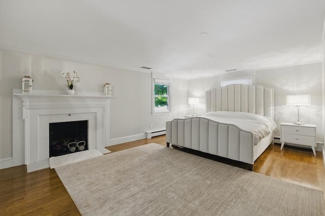 290 Lyman Rd, Milton, MA 02186 - bedroom with a baseboard radiator, wood finished floors, a fireplace with flush hearth, crown molding, and baseboards