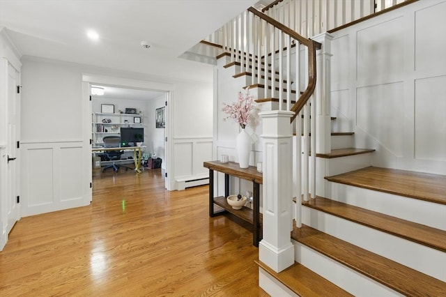290 Lyman Rd, Milton, MA 02186 - stairs with a decorative wall, baseboard heating, wood finished floors, wainscoting, and built in features