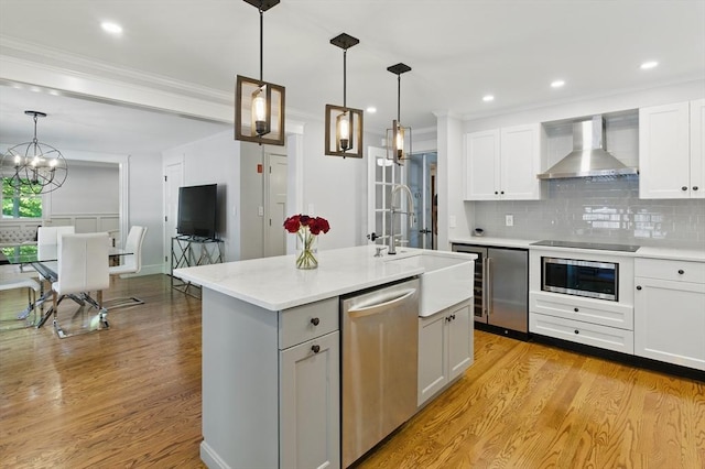 290 Lyman Rd, Milton, MA 02186 - kitchen with dishwasher, wall chimney range hood, light wood finished floors, a chandelier, and ornamental molding