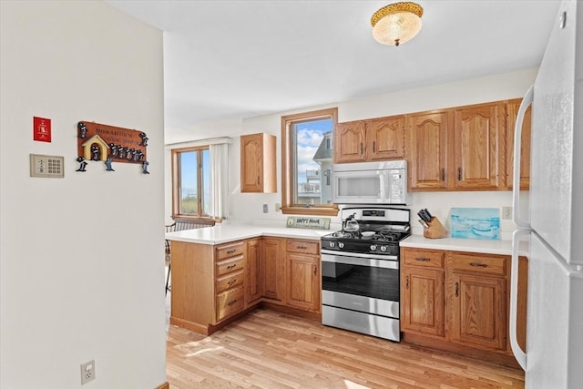 492 N End Blvd, Salisbury, MA 01952 - kitchen featuring white appliances, light wood-type flooring, light countertops, a peninsula, and brown cabinets