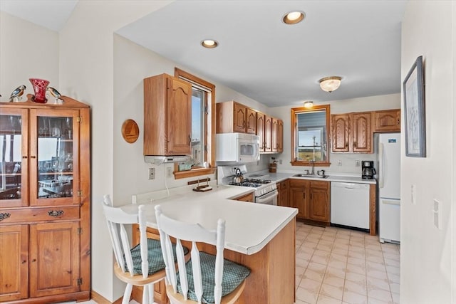 492 N End Blvd, Salisbury, MA 01952 - kitchen featuring white appliances, a peninsula, light countertops, brown cabinetry, and recessed lighting
