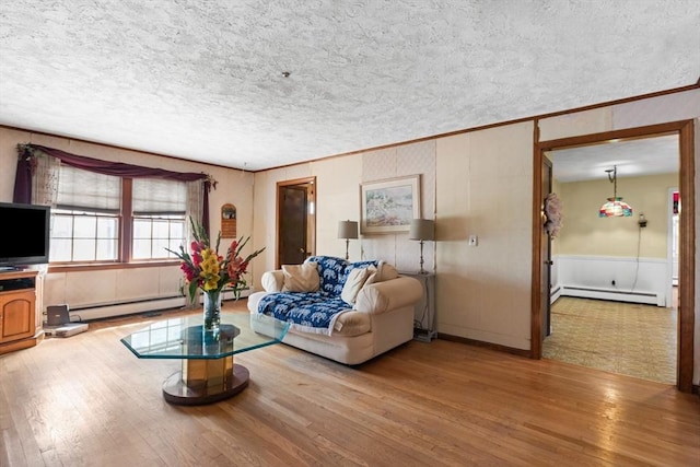 living area featuring a baseboard heating unit, wood finished floors, and a textured ceiling