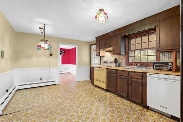 kitchen with light countertops, range with electric cooktop, a sink, wainscoting, and dishwasher