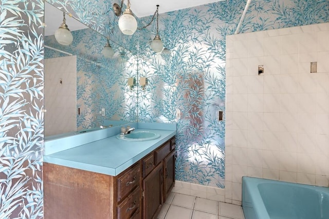 bathroom featuring wallpapered walls, a bath, tile patterned floors, and vanity