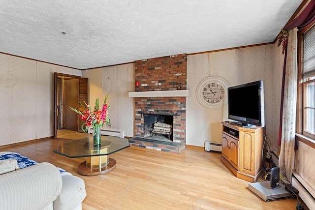living area featuring wood finished floors, ornamental molding, a baseboard heating unit, a textured ceiling, and baseboard heating