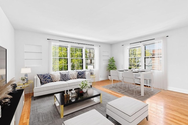 living room featuring plenty of natural light, baseboards, and wood finished floors