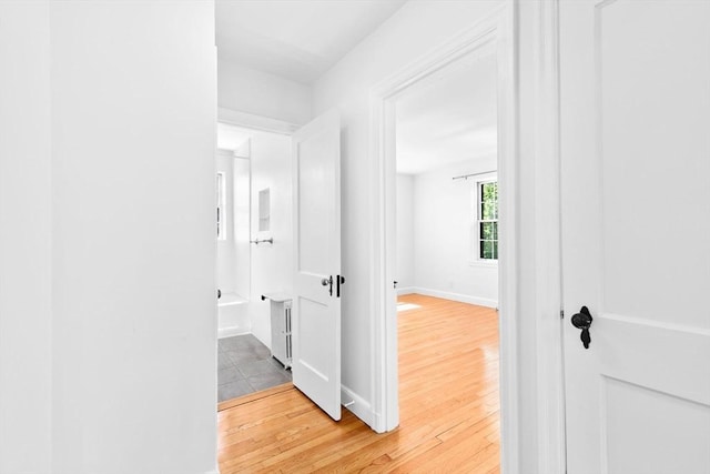 hallway featuring wood finished floors and baseboards