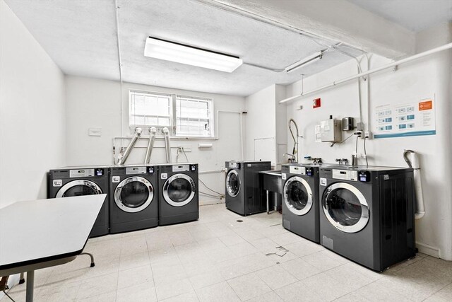 community laundry with washing machine and dryer and tile patterned floors