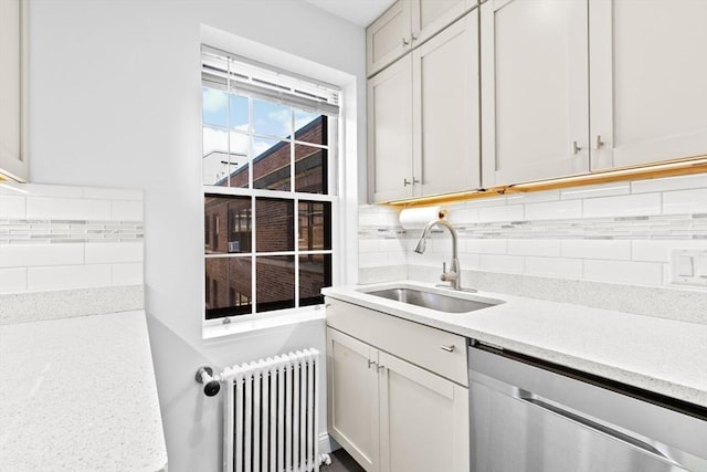 washroom with radiator and a sink