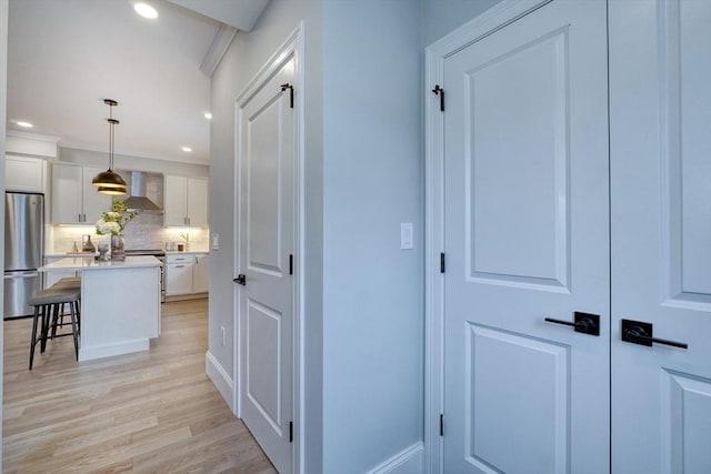 corridor featuring crown molding and light hardwood / wood-style flooring