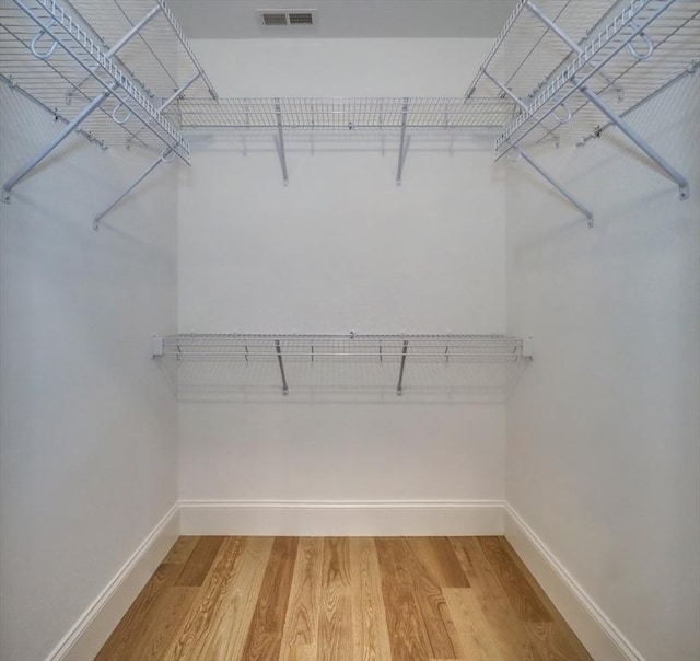 walk in closet with hardwood / wood-style flooring